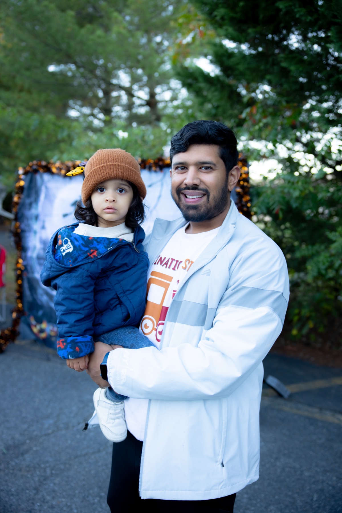 A parent holding a young child at SiRa Dentistry's 2025 Halloween event